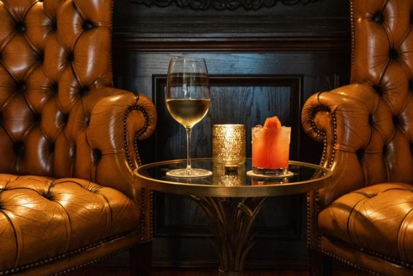Two leather seats situated around a table with cocktails