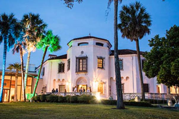 Exterior view of McNay Art Museum at dusk with green backlight.