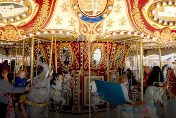 Children on a carousel at theme park.