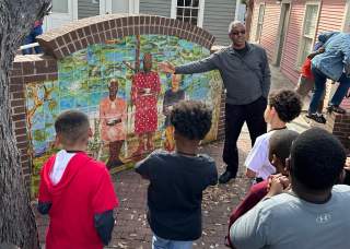 Man explaining piece of artwork to group